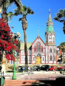 Kościół z palmą przed nim w obiekcie CÓMODO Y RENOVADO DEPARTAMENTO CON VISTA AL MAR w mieście Arica