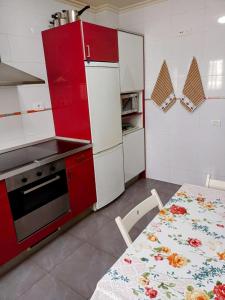 a kitchen with red and white appliances and a table with a table sidx sidx sidx at PONIENTE in Gijón