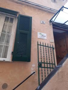 a building with a green door and a gate at La Maison de Lusè à Sanremo in Sanremo