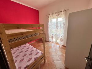 a bedroom with two bunk beds and a red wall at Casa Fiorella in Fiano Romano