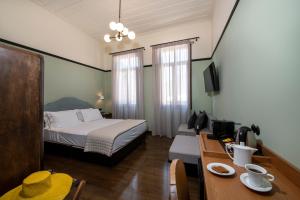 a hotel room with a bed and a desk with a table at Mosaic Venetian Harbour Suites in Chania
