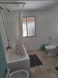 een badkamer met een toilet en een bad met een douche bij Casiña Flor do Maravillas Roblido in Roblido