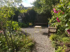 a garden with a bench and some flowers at 1 Taits Flat in Orkney