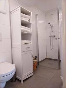 ein weißes Bad mit einer Dusche und einem WC in der Unterkunft Kjellerleilighet i Fana til leie in Bergen