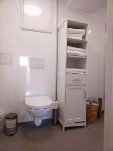 Baño blanco con aseo y toallas en Kjellerleilighet i Fana til leie-med gratis parkering og mange kollektiv reisemuligheter, en Bergen 36 fotos más