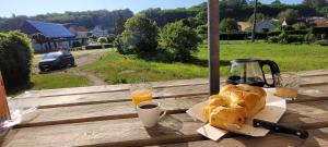 a table with a plate of bread and orange juice at La Graine de Beurre proche zoo de Beauval in Seigy