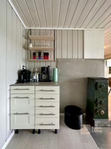 eine Küche mit einer weißen Kommode in einem Zimmer in der Unterkunft Close to nature cabin, sauna, Øyeren view, Oslo vicinity in Hektner