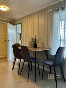einen Esstisch und Stühle mit Pflanze drauf in der Unterkunft Close to nature cabin, sauna, Øyeren view, Oslo vicinity in Hektner