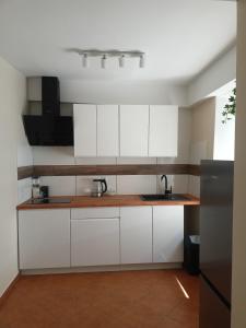 a kitchen with white cabinets and a sink at Apartament 592 in Boguszów-Gorce