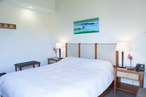 sypialnia z dużym białym łóżkiem i dwoma stołami w obiekcie Hotel Maitei Posadas w mieście Posadas