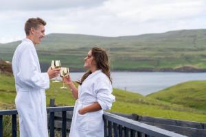 Ein Mann und eine Frau mit Weingläsern. in der Unterkunft AURORA rural RETREATs in Glendale