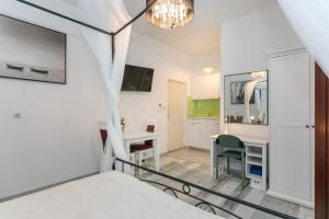 a bedroom with a bed and a desk and a table at Apartments Delfin in Krk