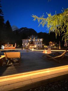 a deck with benches and a house at night at Chalet Queen in Canazei