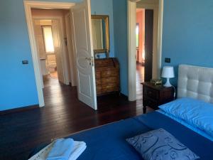 - une chambre avec un lit bleu et une porte menant à un couloir dans l'établissement Remarkable 6 bedrooms Villa in Cerrione with land, à Cerrione