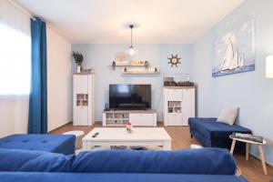 salon z niebieską kanapą i telewizorem w obiekcie Apartment Blue Anchor w mieście Zadar
