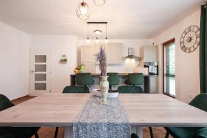 jadalnia z drewnianym stołem i zielonymi krzesłami w obiekcie Apartment Blue Anchor w mieście Zadar