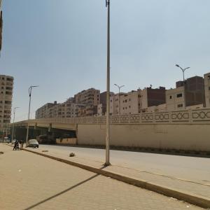 una strada cittadina con un ponte sullo sfondo di Economy Pyramids a Il Cairo