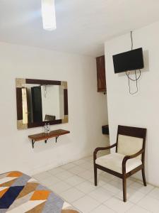 uma sala de estar com uma cadeira e um espelho em Hotel Costa Belle em Monte Gordo