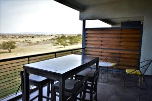 una mesa y sillas en un balcón con vistas al desierto en Gran Depto 2dorm Los Molinos PREVIAJE en Villa General Belgrano