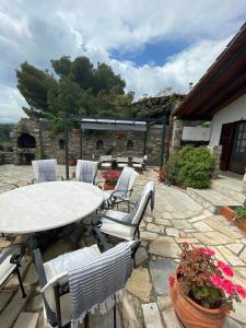 a table and chairs on a stone patio at villa athos in Sarti +18 photos