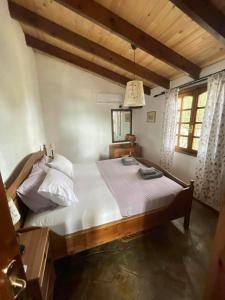 een slaapkamer met een groot bed met witte lakens bij villa athos in Sarti