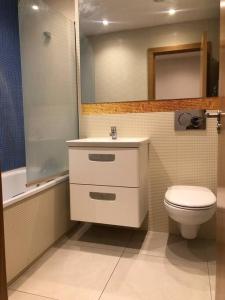een badkamer met een toilet, een wastafel en een spiegel bij Flat in North Acton in Londen