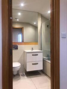 een badkamer met een toilet, een wastafel en een spiegel bij Flat in North Acton in Londen