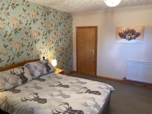 a bedroom with a bed with a flowery wallpaper at The Coffee Pot accommodation in Dufftown