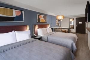 um quarto de hotel com duas camas e uma secretária em Atwell Suites Austin Airport, an IHG Hotel em Austin