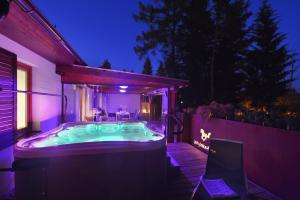 a hot tub in the backyard of a house at night at Rekreační domek Kobylnice Lipno in Lipno nad Vltavou