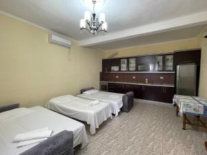 Habitación hospitalaria con 2 camas y nevera en VG Holiday's Rooms, en Borsh