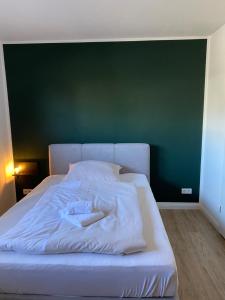 Ce lit se trouve dans un dortoir doté d'un mur vert. dans l'établissement Bude 8, à Flensbourg