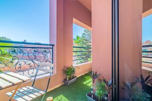 a balcony with a bed and plants on it at Caprice palace hivernage in Marrakesh