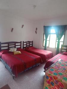 1 dormitorio con 2 camas y ventana en Hostal Mario's Rooms, en Panajachel