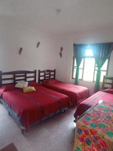 a bedroom with two beds and a window at Hostal Mario's Rooms in Panajachel