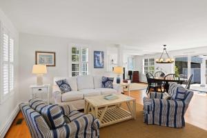 ein Wohnzimmer mit Sofa, Stühlen und einem Tisch in der Unterkunft 2 Bicycles Provided! Cape Cod Cottage with Deck in Orleans