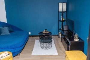 Cette chambre bleue comprend un lit et une table. dans l'établissement Blue Vibes, à Saint-Avold