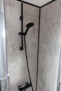 La salle de bains est pourvue d'une douche avec un pommeau de douche noir. dans l'établissement Blue Vibes, à Saint-Avold