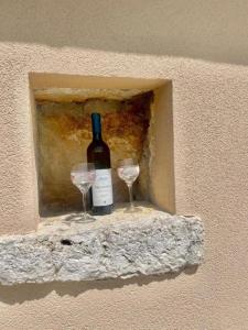Una botella de vino y dos copas en una pared. en Holiday house ISIDORA, en Danilovgrad