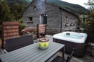 a bath tub sitting on a deck next to a table at Birken Suite in Ramsau