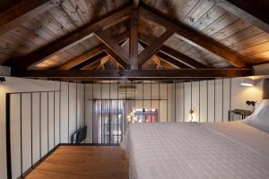 a bedroom with a large bed in a room with wooden ceilings at Mosaic Venetian Harbour Suites in Chania Town