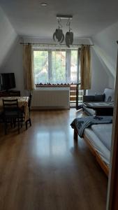 a bedroom with a bed and a table and a window at Willa Seba in Zakopane