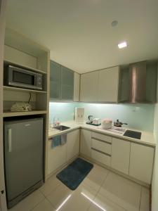 a kitchen with white cabinets and a microwave at KLCC by SWITZHOME in Kuala Lumpur