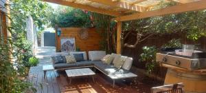 a patio with a couch and a grill at Charmante maisonnette proche plage in Fréjus