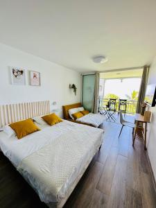 sypialnia z dużym łóżkiem i balkonem w obiekcie Joli Studio Kaz’Coco vue mer w mieście Le Diamant