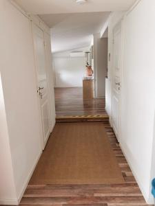 瓦爾貝里的住宿－Tofta Konstgalleri-Hel Lägenhet 70kvm，空的走廊,有白色的墙壁和木地板