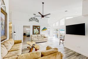 a living room with two couches and a flat screen tv at Dolphin Court #9 in St Pete Beach
