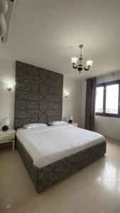 een slaapkamer met een groot bed en een bakstenen muur bij Hawana salalah luxury apartment in Ma‘mūrah