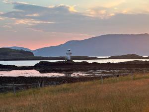 a lighthouse in the middle of a body of water at Lurach House - Ukc6791 in Port Appin