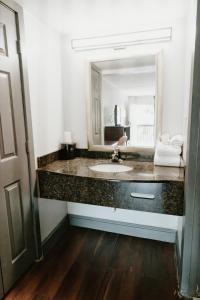 a bathroom with a sink and a large mirror at Sandston Inn in Sandston